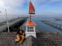 Foreman, Donald Jusseaume of R. P. Valois & Company installs the cupola and copper sailboat weathervane atop the new Maritime Center in Padanaram on a foggy morning.  [ PETER PEREIRA/THE STANDARD-TIMES ]