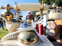 A customer walks in the background, as Steve Long puts out the over one thousand iitems, including the old style telephone, on his tables at the weekly Mattapoisett Flea Market held every Tuesday in front of the Knights of Columbus Hall on Route 6 in Mattapoisett.   [ PETER PEREIRA/THE STANDARD-TIMES/SCMG ]