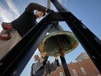 Friar John gives James Androuais of the Americlock company a hand, in installing a new steel  bell frame and automation package on top of Our Lady's Chapel high above downtown New Bedford.   [ PETER PEREIRA/THE STANDARD-TIMES ]