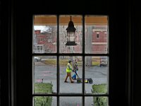 Seen through a window of the James Arnold Mansion in New Bedford, Radar Solution International VP Cameron Russ, and Tom Elmore of the Geonav Group, survey the area around the Wamsutta Club using ground penetrating radar, in an effort to 'see' which clues to the past still lay unseen below the surface of the parking lot.  [ PETER PEREIRA/THE STANDARD-TIMES/SCMG ]