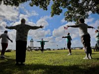 Mary Beth Soares, center, leads a  session of Tai Chi, in front of the Ned's Point Lighthouse in Mattapoisett, as part of the Mattapoisett Council on Aging's weekly free sessions held Monday mornings between 8:45 and 9:45.  The next session will be held on September 16th at the Council on Aging on Barstow Street in Mattapoisett.  [ PETER PEREIRA/THE STANDARD-TIMES/SCMG ]