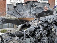 The owner of the vehicle that caught fire in front of St. Lukes hospital in New Bedford can be seen through a gap in the still smoldering engine compartment of his Mercedes.  [ PETER PEREIRA/THE STANDARD-TIMES ]