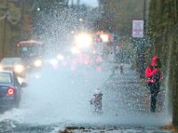 A student walking to school is doused by a wall of water being thrown up by a car driving over the high standing water on Parker Street in New Bedford. on a very wet morning.  [ PETER PEREIRA/THE STANDARD-TIMES/SCMG ]