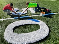 Stacey Wills and Jesus Adame of Sprinturf, align the white turf numbers, before cutting them and gluing them into place on the new football field they are constructing at Fairhaven High School in preparation for the first game to be played on the new surface sometime early next month.