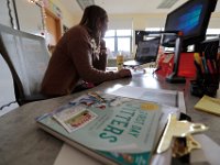 Courtney Lima answers parents emails, while on her dest a book entitled 'First day Jitters' about a teacher on her first day. Courtney Lima who attended the Taylor School in New Bedford as a student for grades K-6, returns for her first day of school, this time as a third grade teacher. Ms. Lima will be teaching third graders virtually this year, as part of the Distance Learning Academy for students who opted to stay home for this school year.  PHOTO PETER PEREIRA