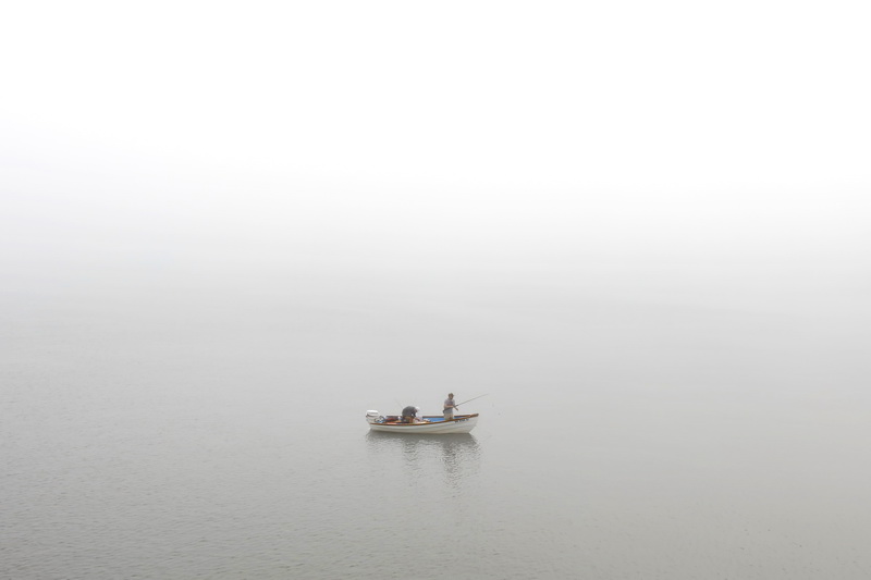 Duane Young-Kershaw and Kevin Sullivan find themselves surrounded by fog, as they fish on the Westport River on a hot morning in Westport, MA.  PHOTO PETER PEREIRA