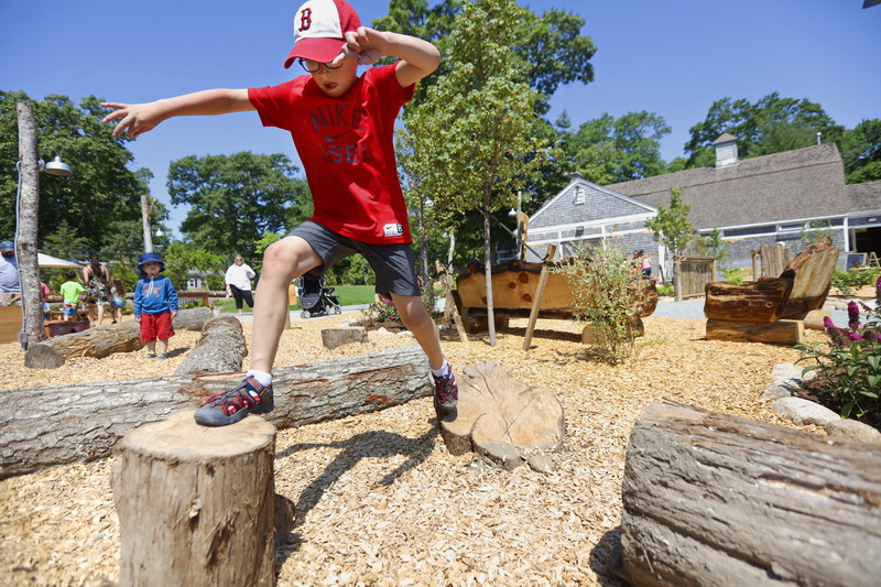 Landon Almeida, 8, jumps between logs at the just opened Charlie's Nature Play area at the Buttonwood Park Zoo in New Bedford, MA. PHOTO PETER PEREIRA