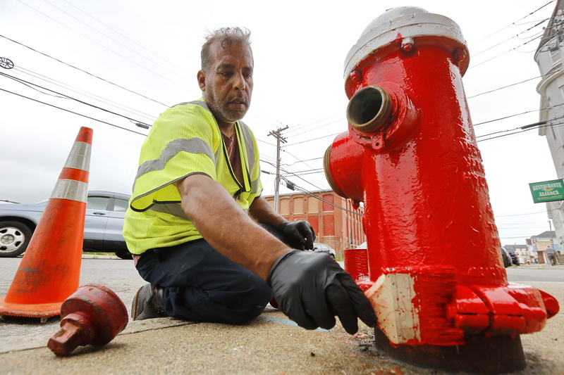 Ismael Rivera paints a fire hydrant on Cove Street in the south end of New Bedford as the DPI department goes about re-painting every one of the city's hydrants. PHOTO PETER PEREIRA
