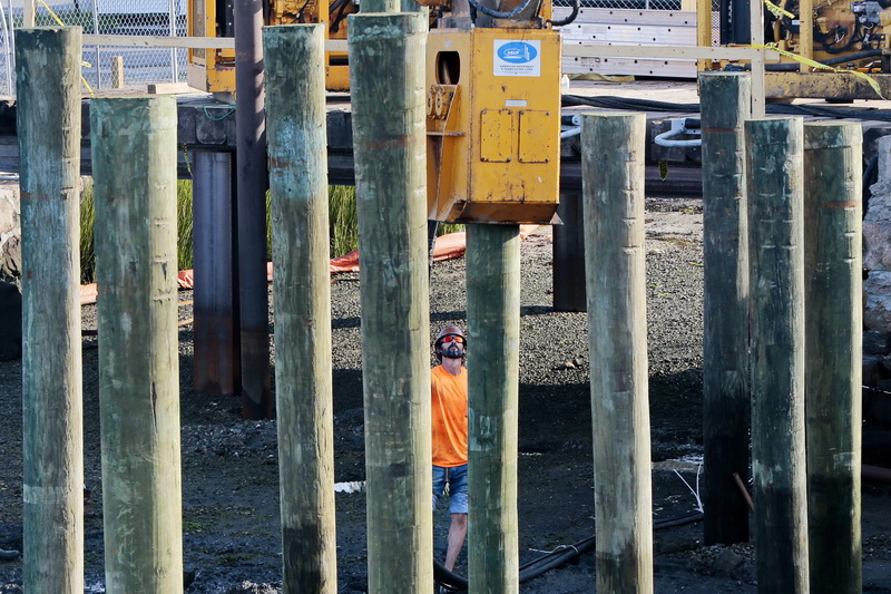 A worker monitors a pile driver installing a pile for a new dock off of Water Street in Padanaram, MA. PHOTO PETER PEREIRA