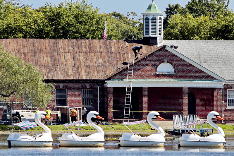The swan boats are all lined up as workmen install a new roof at the Buttonwood Senior Center at Buttonwood Park in New Bedford, MA.