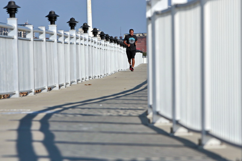 A man goes for an early morning run on the Harborwalk built atop the hurrican barrier in the south end of New Befford, MA. PHOTO PETER PEREIRA