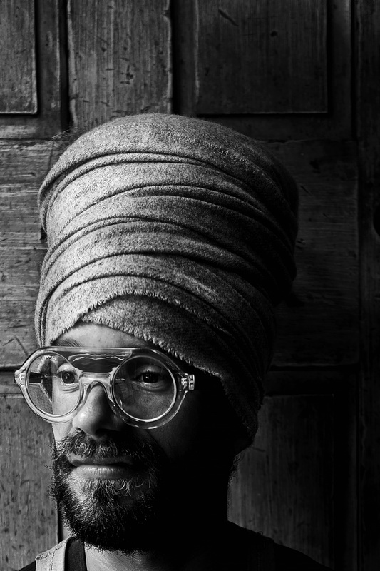 Portrait of local artist Andrew Kepinski, at Tia Maria's European Cafe in New Bedford, MA wearing his trademark head wrap.  PHOTO PETER PEREIRA