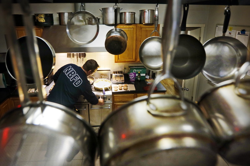 At the beginning of his two day shift, firefighter Mike Branco prepares breakfast consisting of, scrambled eggs, sausage, toast and bacon for himself, and for his fellow firefighters who slept at Station 8 on Acushnet Avenue in New Bedford, MA. PHOTO PETER PEREIRA