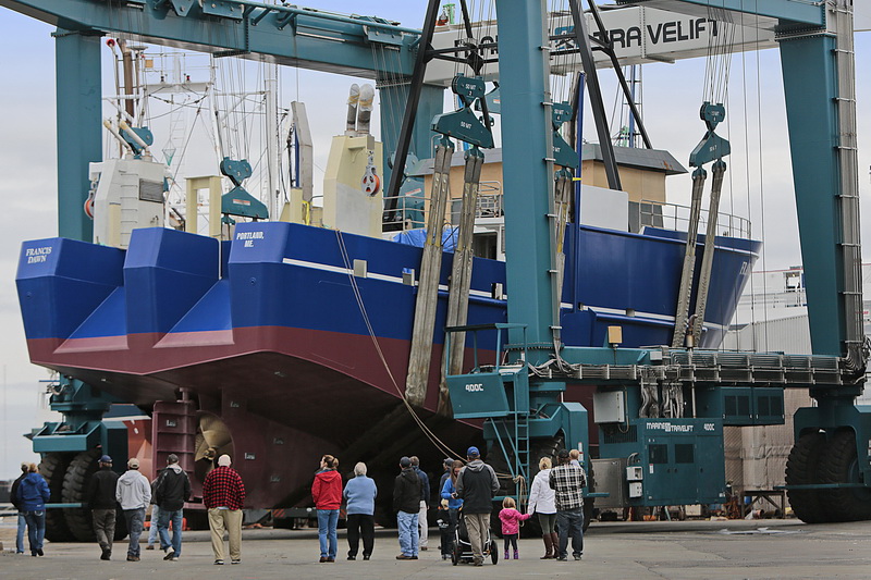 Mark Bichrest and his family and friends from his hometown in Maine, watch his just completed dragger, F/V Francis Dawn being moved to be placed in the water for the first time where it was built at the Fairhaven Shipyard.  Once in the water, the fishing boat's insides and rigging will be completed, before Mr. Bichrest sails it back to Maine. PHOTO PETER PEREIRA