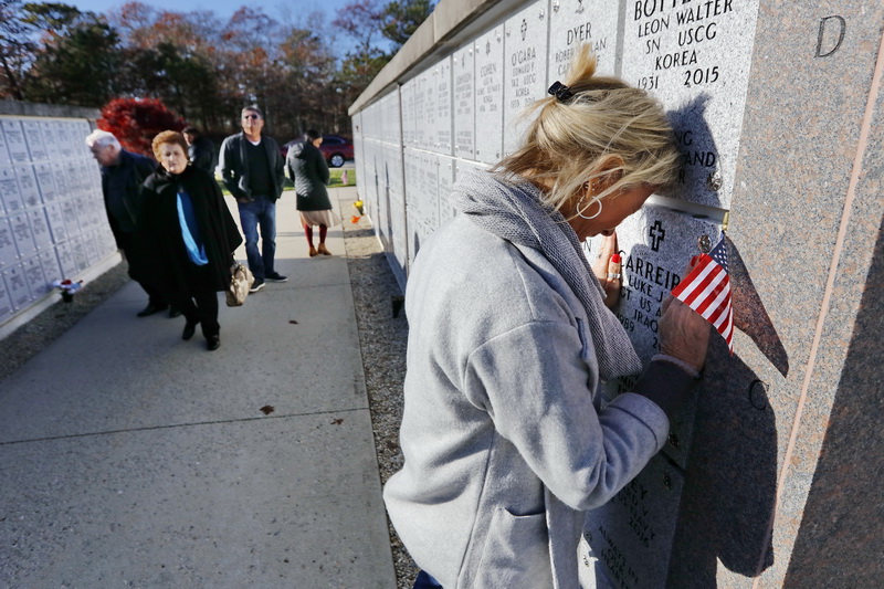 Her family waits, as an emotional Marie Carreiro spends a few last minutes at the gravesite of her son Luke Carreiro at the National Cemetery in Bourne, MA on Veterans Day. An Army Iraqi war veteran, Luke Carreiro, 26, commited suicide in 2015 while stationed at Fort Bragg in North Carolina.  This is part of a project I am doing on veterans dealing with PTSD, addiction and suicide.  PHOTO PETER PEREIRA
