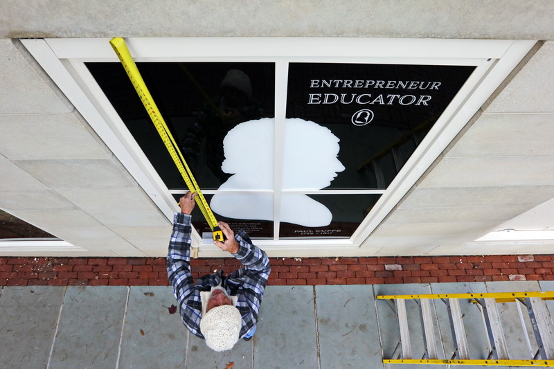 Dana Costa installs a new panel celebrating Paul Cuffe in front of the newly finished Captain Paul Cuffe Park at the Whaling Museum in downtown New Bedford, MA. PHOTO PETER PEREIRA