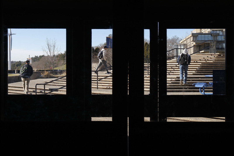 UMass Dartmouth students are seen through different glass portions of the Campus Center doors, as they make their way to class. PHOTO PETER PEREIRA