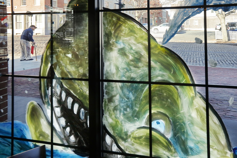 A man crossing Union Street in downtown New Bedford, MA finds himself in the path of an angry whale painted on the windows of the Moby Dick Brewery.   PHOTO PETER PEREIRA