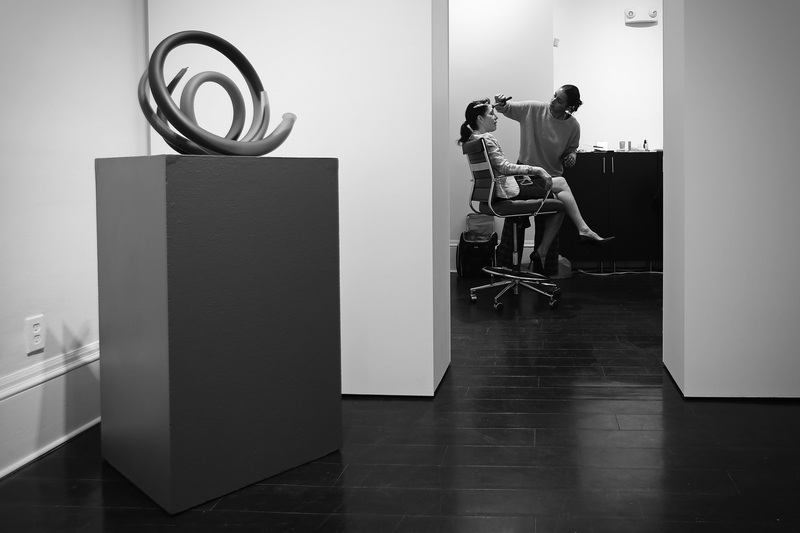 Makeup artist Jayliana Brito prepares New Bedford Art Museum director Suzanne de Vegh for a photo shoot.  In the foreground Radio Loops by Pual Seides is one of the many glass pieces featured in Pathfinders: Paving the Glass Revolution in the U.S. opening soon at the museum. PHOTO PETER PEREIRA