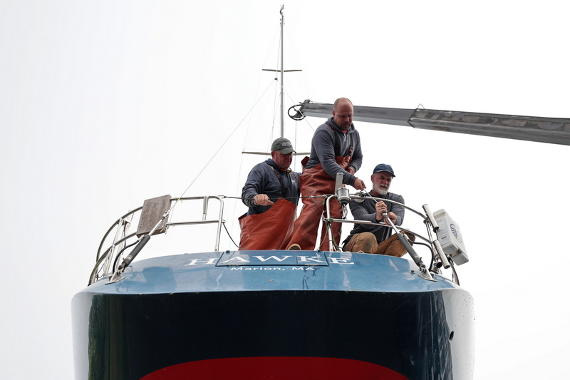 Brownell Systems workers rig the sailboat Hawke before putting it in the water in Mattapoisett, MA. PHOTO PETER PEREIRA