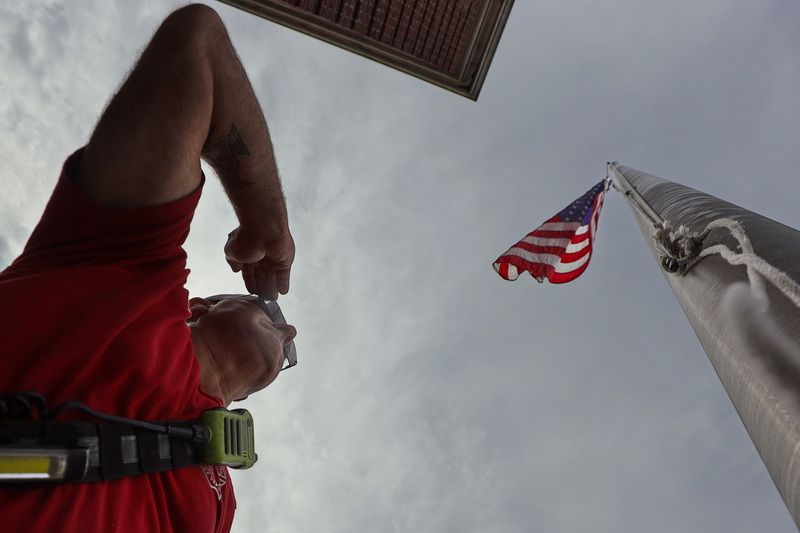 Firefighter Fred Carreiro salutes the American flag after lowering it to half-mast during a ceremony commemorating 9/11 victims held in front of the New Bedford Fire Department Headquarters on September 11, 2026. PHOTO PETER PEREIRA