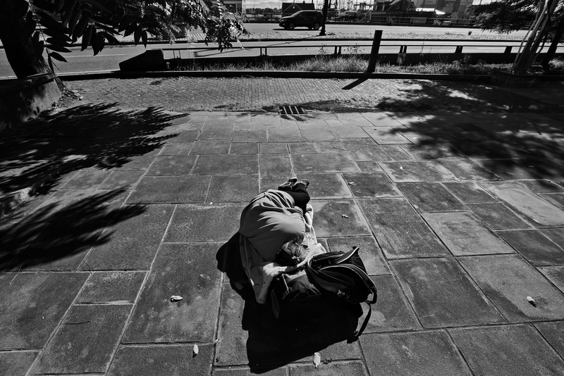 A homeless woman sleeps on the sidewalk as vehicles make their way up Route 18 in New Bedford, MA on September 15, 2026. PHOTO PETER PEREIRA