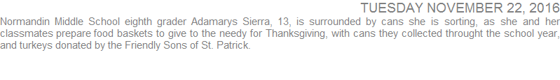 Normandin Middle School eighth grader Adamarys Sierra, 13, is surrounded by cans she is sorting as she and her classmates prepare food baskets to give to the needy for Thanksgiving, with cans they collected throught the school year and turkeys donated by the Friendly Sons of St. Patrick
