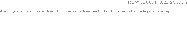 A youngster runs across William St. in downtown New Bedford with the help of a blade prosthetic leg.