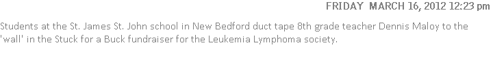 Students at the St. James St. John school in New Bedford duct tape 8th grade teacher Dennis Maloy to the 'wall' in the Stuck for a Buck fundraiser for the Leukemia Lymphoma society.