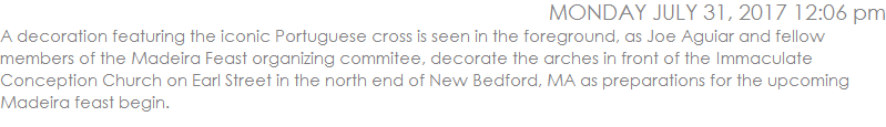 A decoration featuring the iconic Portuguese cross is seen in the foreground, as Joe Aguiar and fellow members of the Madeira Feast organizing commitee, decorate the arches in front of the Immaculate Conception Church on Earl Street in the north end of New Bedford, MA as preparations for the upcoming Madeira feast begin. 