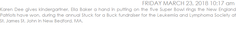 Karen Dee gives kindergartner, Ella Baker a hand in putting on the five Super Bowl rings the New England Patriots have won, during the annual Stuck for a Buck fundraiser for the Leukemia and Lymphoma Society at St. James St. John in New Bedford, MA.