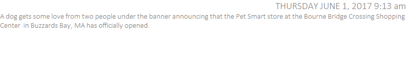 A dog gets some love from two people under the banner announcing that the Pet Smart store at the Bourne Bridge Crossing Shopping Center  in Buzzards Bay, MA has officially opened.
