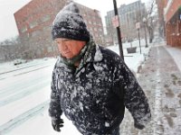Bob Marker's jacket is caked in snow as he makes his way up Purchase Street in downtown New Bedoford as another late season snow storm rolls over the region.   [ PETER PEREIRA/THE STANDARD-TIMES/SCMG ]