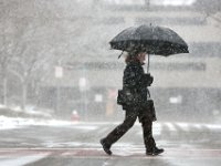 A woman walks across Middle Street in New Bedford as snow begins falling across the region.   [ PETER PEREIRA/THE STANDARD-TIMES/SCMG ]