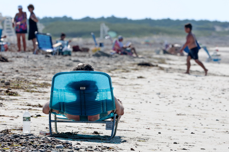 A beachgoer casts a shadow of his profile on his beach chair as he catches some rays at Horseneck Beach in Westport, MA on a blistering hot day.  PHOTO PETER PEREIRA
