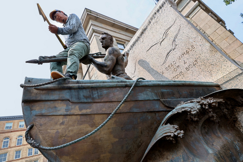 Gompo Yarmolinsky a conservator with Daedalus measures the new bronze harpoon tip he will be installing on the iconic whaleman statue in front of the New Bedford Free Public Library which is currently undergoing extensive conservation.  PHOTO PETER PEREIRA