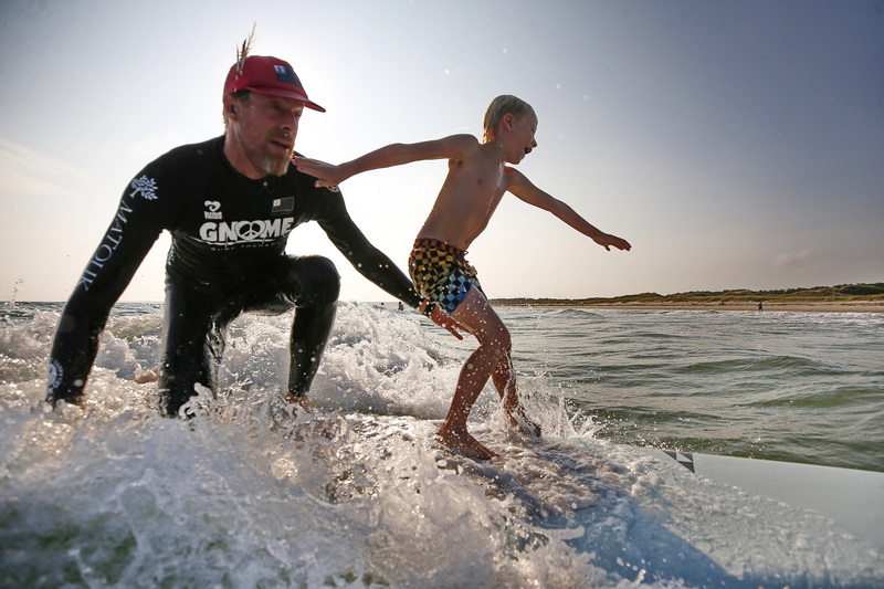 A Gnome Surf instructor helps his student catch a wave during a session at Horseneck Beach in Westport, MA.  Gnome Surf are a non-profit organization providing surf therapy, art therapy, eco therapy and yoga therapy to children and families of all abilities, on the autism spectrum, down syndrome, and the LGBTQ youth. PHOTO PETER PEREIRA
