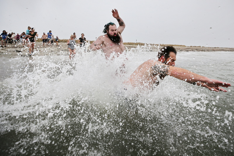 Tyler O'Driscoll and Jamie O'Driscoll, brother of Shannon, send water flying into the air as they dive into the chilly waters on Gooseberry Island in Westport, MA during the yearly Plunge of the Faithful. This event honors Shannon O'Driscoll, who was tragically killed in 2006 by an SUV driver while displaying a sign advocating for organized day care programs in the state. The plunge is part of a fundraising effort that has collected over $40,000 since its inception. PHOTO PETER PEREIRA