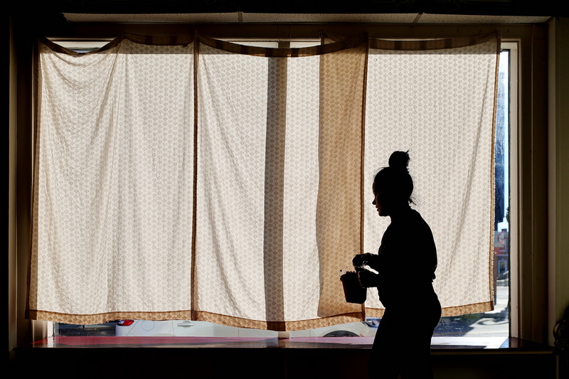 Isabel Gyuge gives her daughter Andreea Furtado a hand in painting the window sills of the future Ink'd Pages bookstore on Union Street in New Bedford, MA due to open early next year. PHOTO PETER PEREIRA