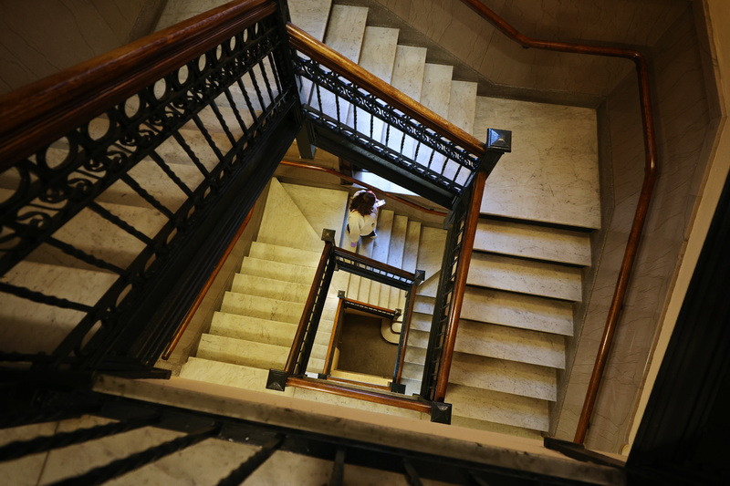 A woman descends the historic marble stairs inside New Bedford City Hall. PHOTO PETER PEREIRA