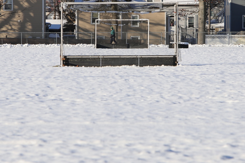 Bryan Medeiros doesn't let the cold or recent snowfall keep him from doing his daily five mile walk around the Cushman Park track in Fairhaven, MA as he is seen through two soccer nets. PHOTO PETER PEREIRA
