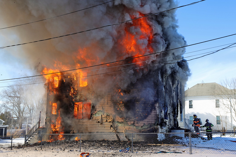 Acushnet firefighters get ready to activate the hoses to combat the blaze through the front door of a residence on Rock Street in Acushnet, MA. PHOTO PETER PEREIRA
