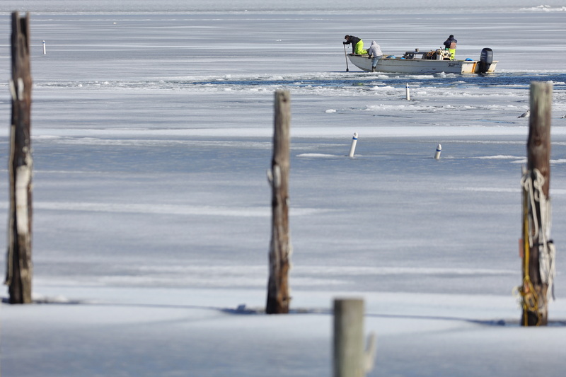 Workers from Blue Stream Shellfish break the ice on West Island in Fairhaven, MA just above their oyster beds, to collect a new supply of oysters. PHOTO PETER PEREIRA