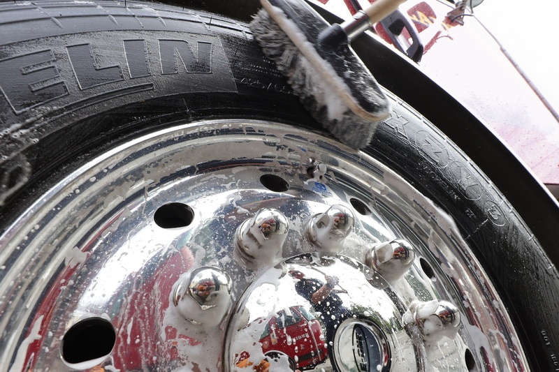 Firefighter Nick Sheehan is seen reflected on the hub cap of the fire truck he is washing at the Marion Fire Department on Spring Street in Marion, MA. PHOTO PETER PEREIRA