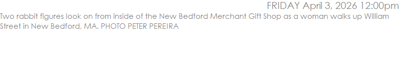 Two rabbit figures look on from inside of the New Bedford Merchant Gift Shop as a woman walks up William Street in New Bedford, MA. PHOTO PETER PEREIRA