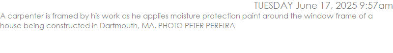 A carpenter is framed by his work as he applies moisture protection paint around the window frame of a house being constructed in Dartmouth, MA. PHOTO PETER PEREIRA
