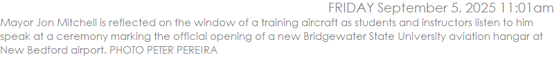 Mayor Jon Mitchell is reflected on the window of a training aircraft as students and instructors listen to him speak at a ceremony marking the official opening of a new Bridgewater State University aviation hangar at New Bedford airport. PHOTO PETER PEREIRA