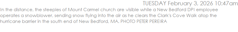 In the distance, the steeples of Mount Carmel church are visible while a New Bedford DPI employee operates a snowblower, sending snow flying into the air as he clears the Clark's Cove Walk atop the hurricane barrier in the south end of New Bedford, MA. PHOTO PETER PEREIRA